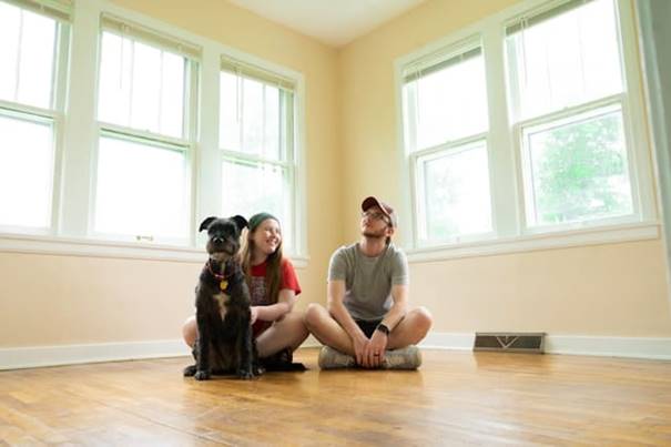 Man en vrouw zitten samen op de grond in een leeg huis